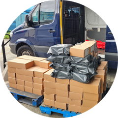 Pallet of cartons loaded beside a delivery van