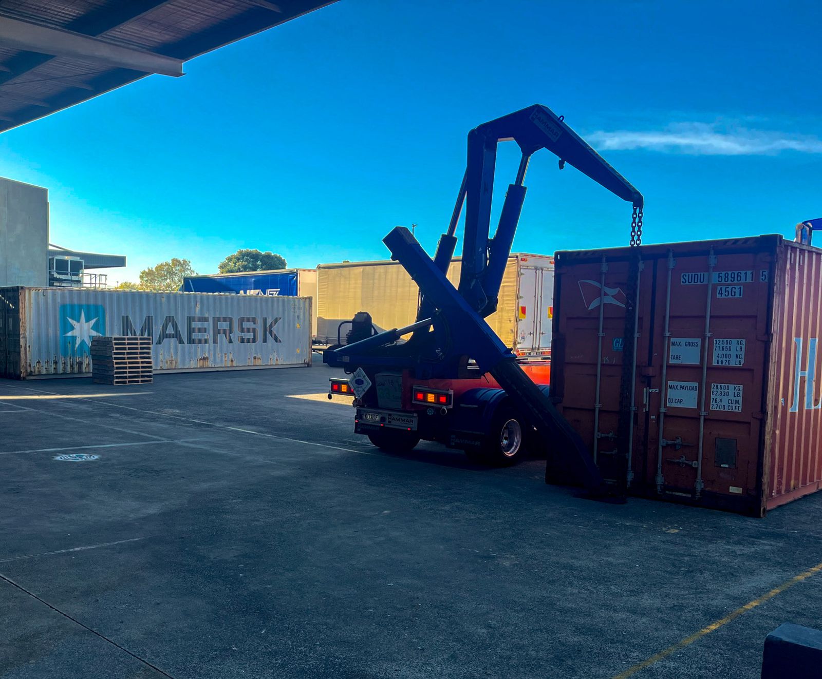 Sidelifter truck setting down a shipping container in the Satellite3PL yard
